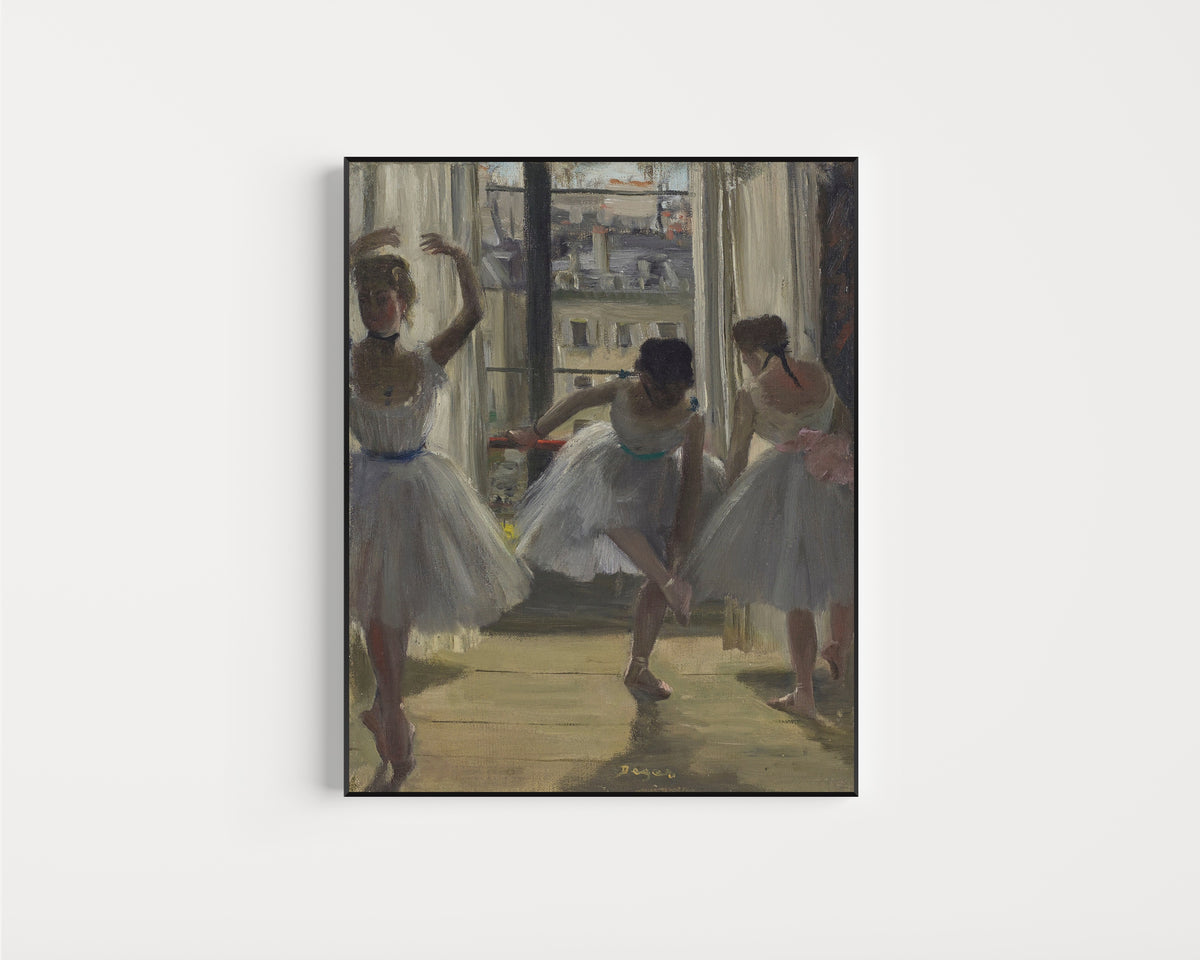 Framed art print of Danseuses dans une salle d’exercice (Trois Danseuses) by Edgar Degas, in a slim black frame on a plain white wall