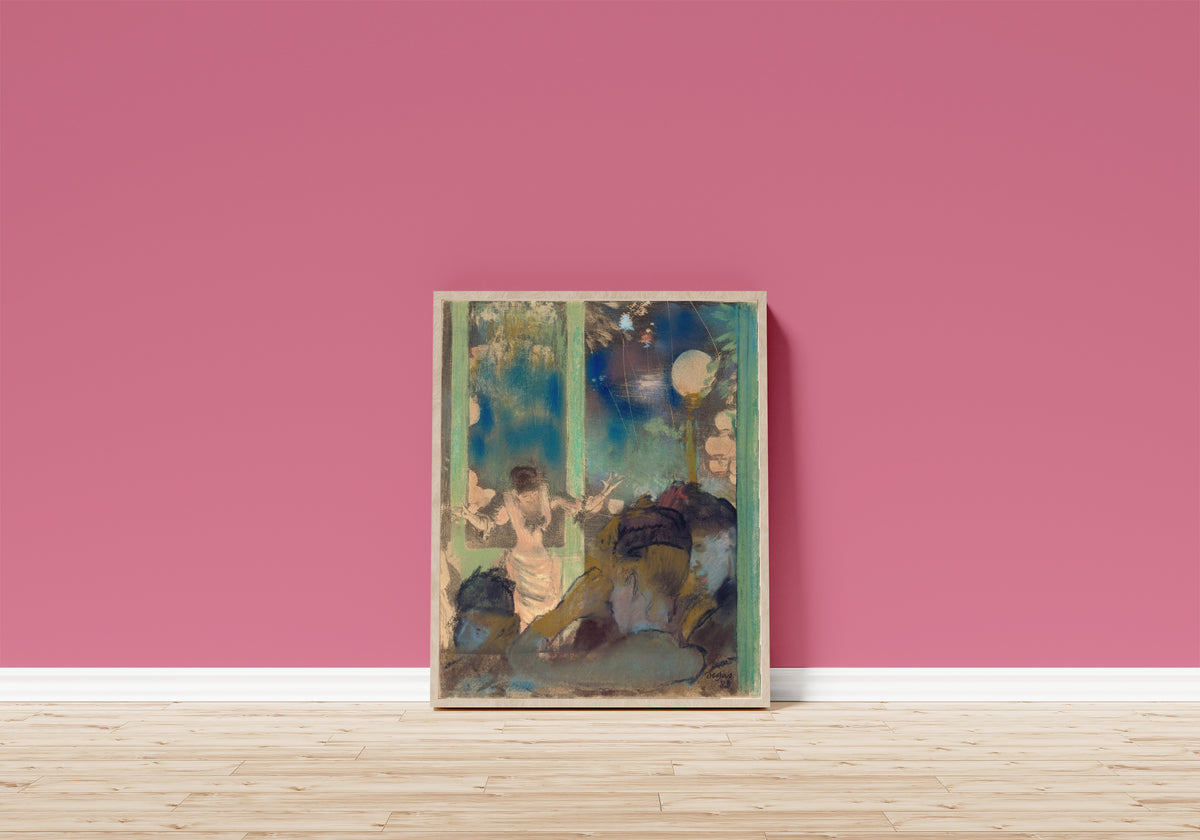 Framed art print of Mademoiselle Bécat at the Café des Ambassadeurs by Edgar Degas, in a light wood frame leaning on a pink wall above a wooden floor