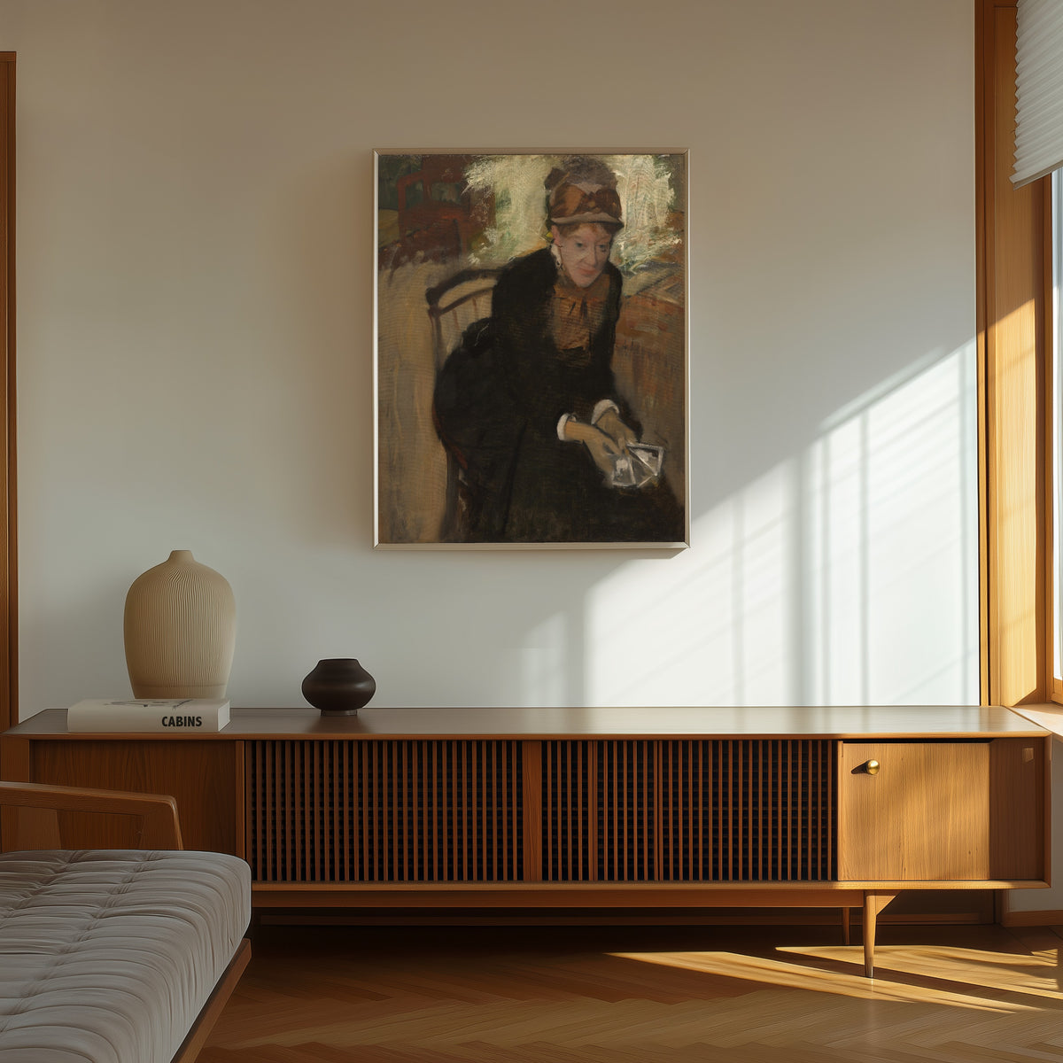 Framed art print of Mary Cassatt by Edgar Degas, in a thin light frame on a sunlit wall above a wooden sideboard