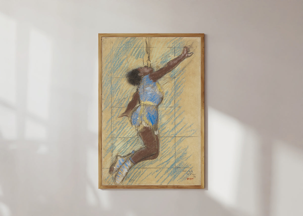 Framed art print of Miss Lala at the Fernando Circus by Edgar Degas, in a light wood frame on a sunlit white wall