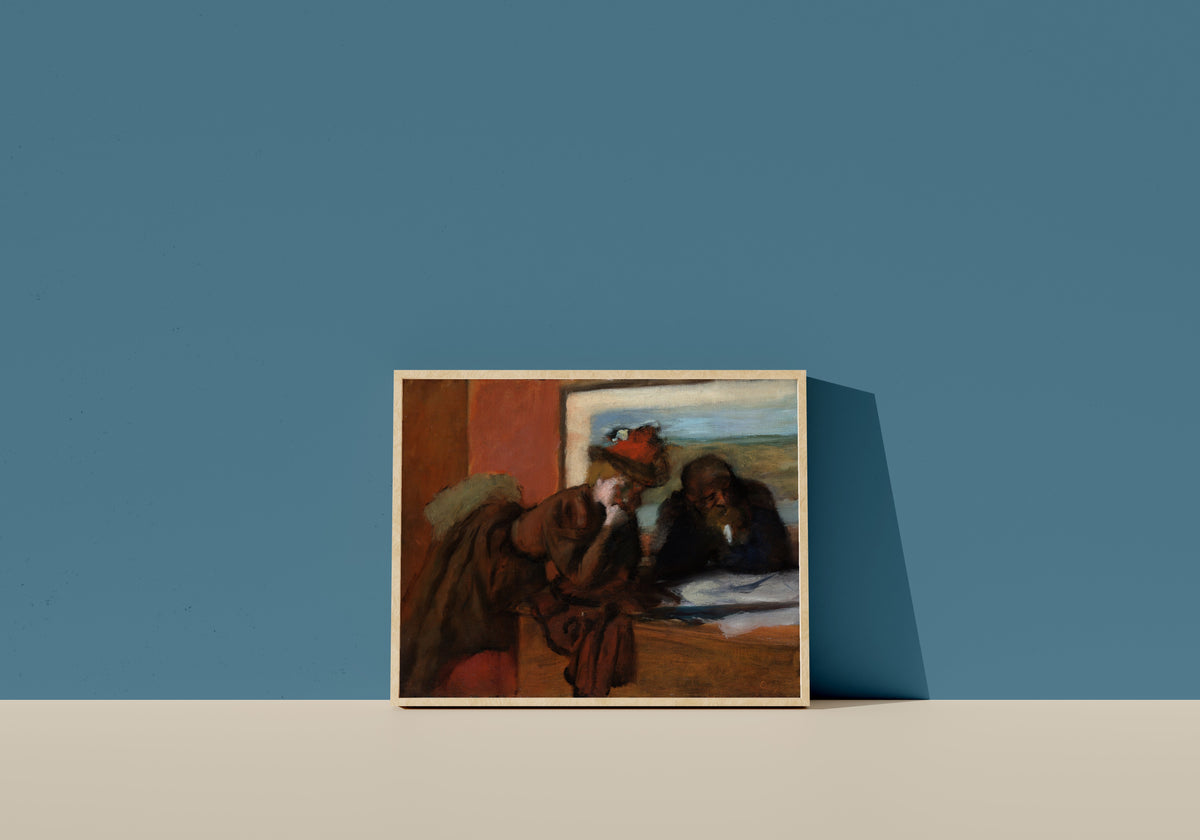 Framed art print of The Conversation by Edgar Degas, in a light wood frame leaning on a blue wall