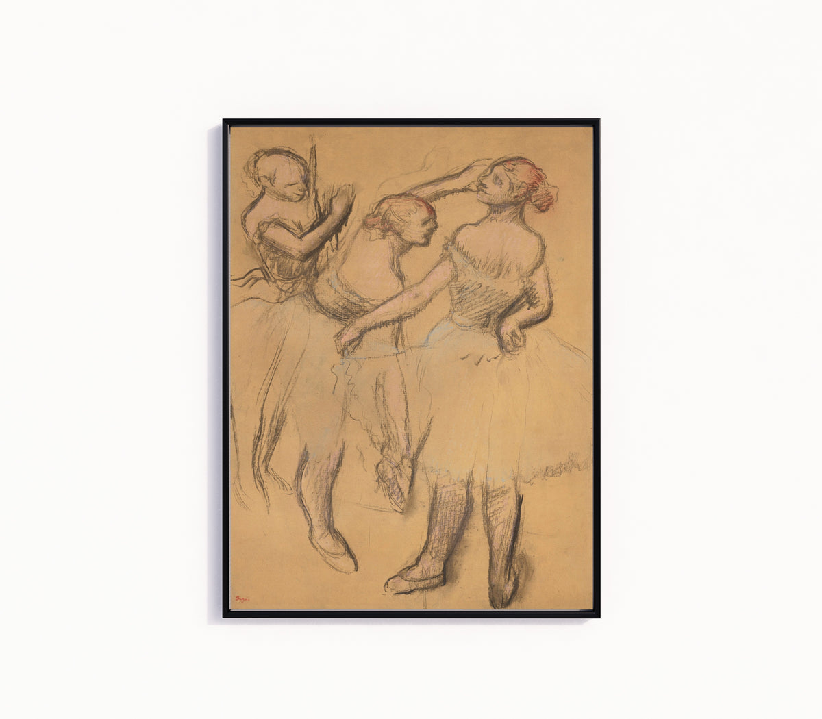Framed art print of Trois danseuses (Dancer with Hand on Hip) by Edgar Degas, in a slim black frame on a plain white wall