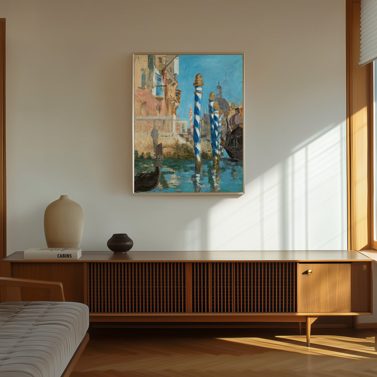 Framed art print of Le Grand Canal à Venise by Édouard Manet, in a thin light frame on a sunlit wall above a wooden sideboard