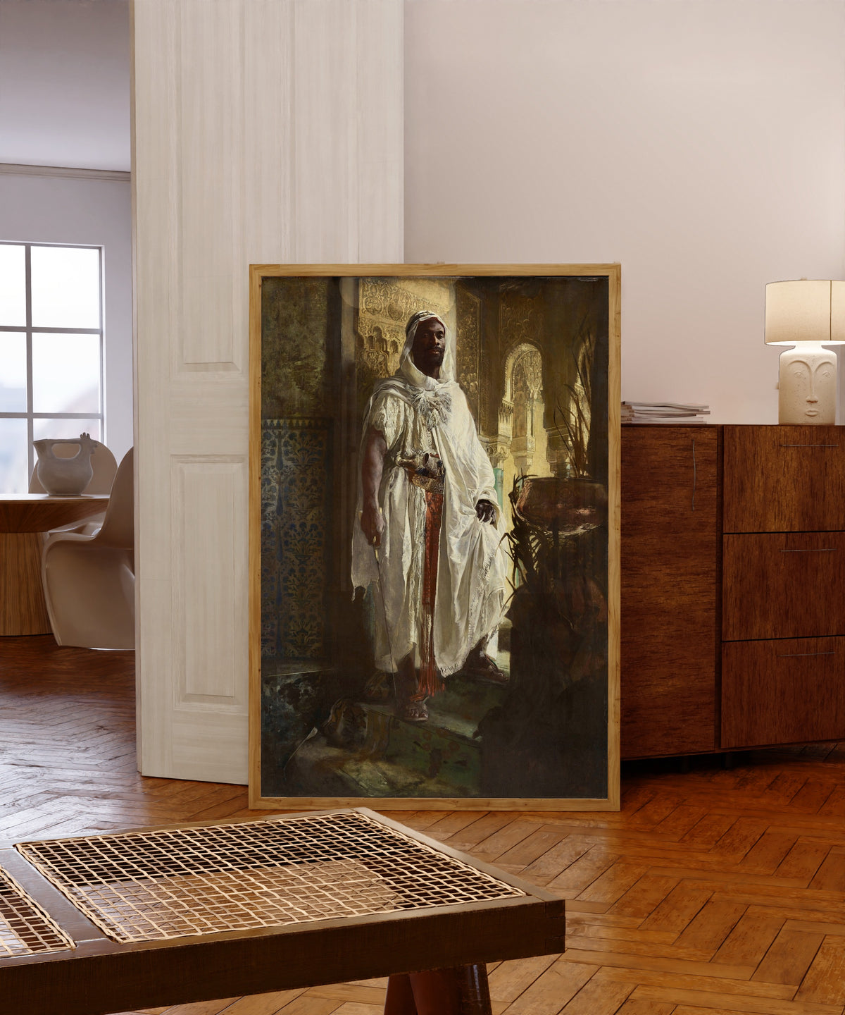 Framed art print of The Moorish Chief by Eduard Charlemont, in a light wood frame leaning in a warm room with a parquet floor