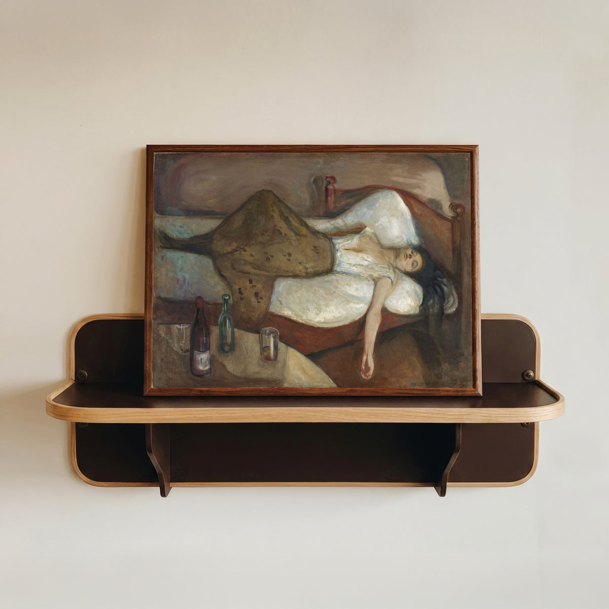 Framed art print of The Day After by Edvard Munch, in a dark wood frame resting on a wall shelf