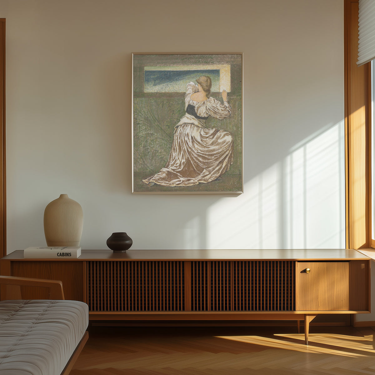 Framed art print of Dorigen de Bretaigne Awaiting the Return of Her… by Edward Burne-Jones, in a thin light frame on a sunlit wall above a wooden sideboard