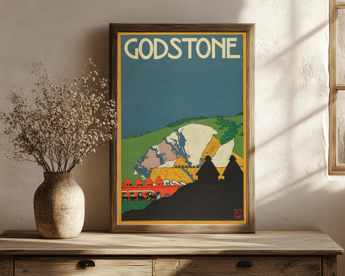 Framed art print of Godstone by Edward McKnight Kauffer, in a dark wood frame leaning on a rustic console beside dried flowers