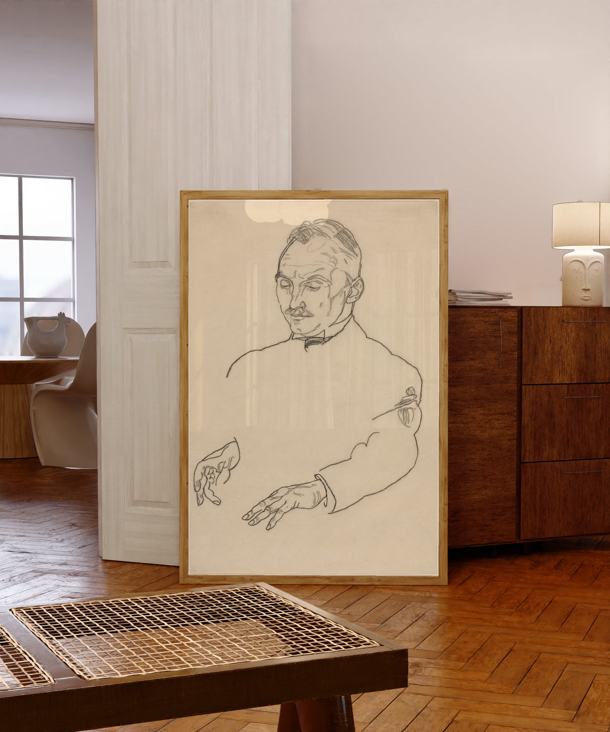 Framed art print of Dr. Koller by Egon Schiele, in a light wood frame leaning in a warm room with a parquet floor