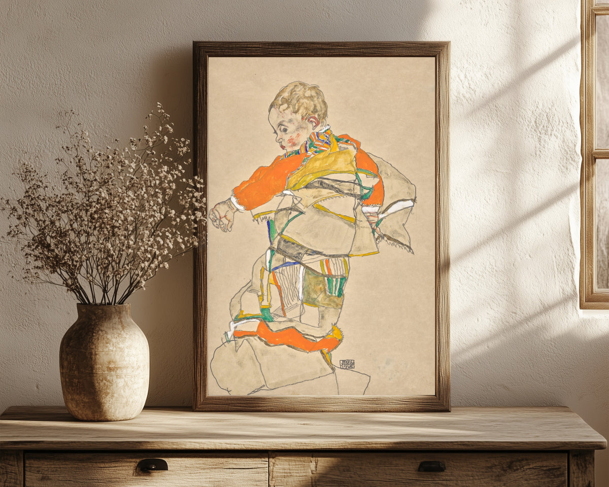 Framed art print of Portrait of a Child (Anton Peschka Jr.) by Egon Schiele, in a dark wood frame leaning on a rustic console beside dried flowers