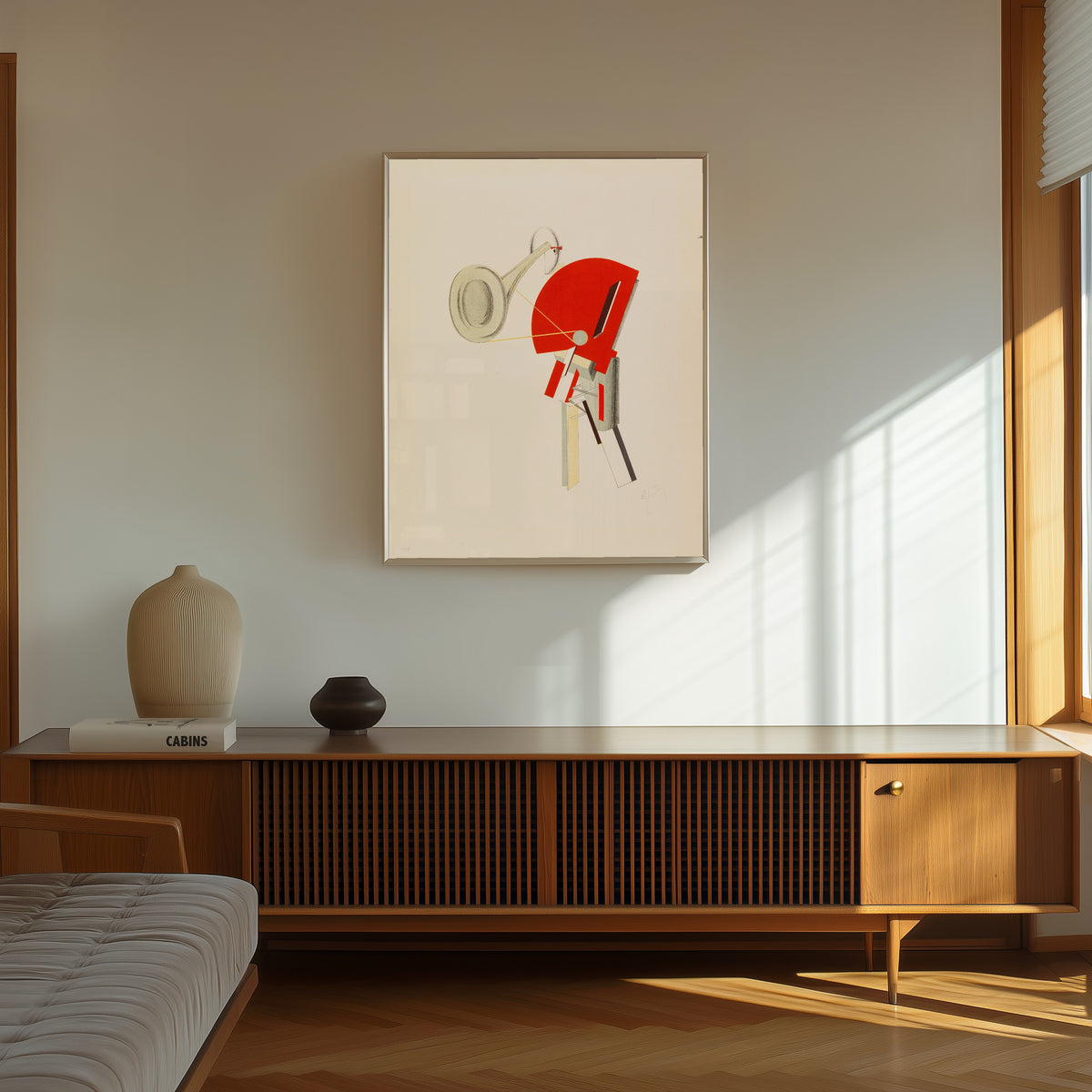 Framed art print of Figurines: The Announcer (Ansager) by El Lissitzky, in a thin light frame on a sunlit wall above a wooden sideboard