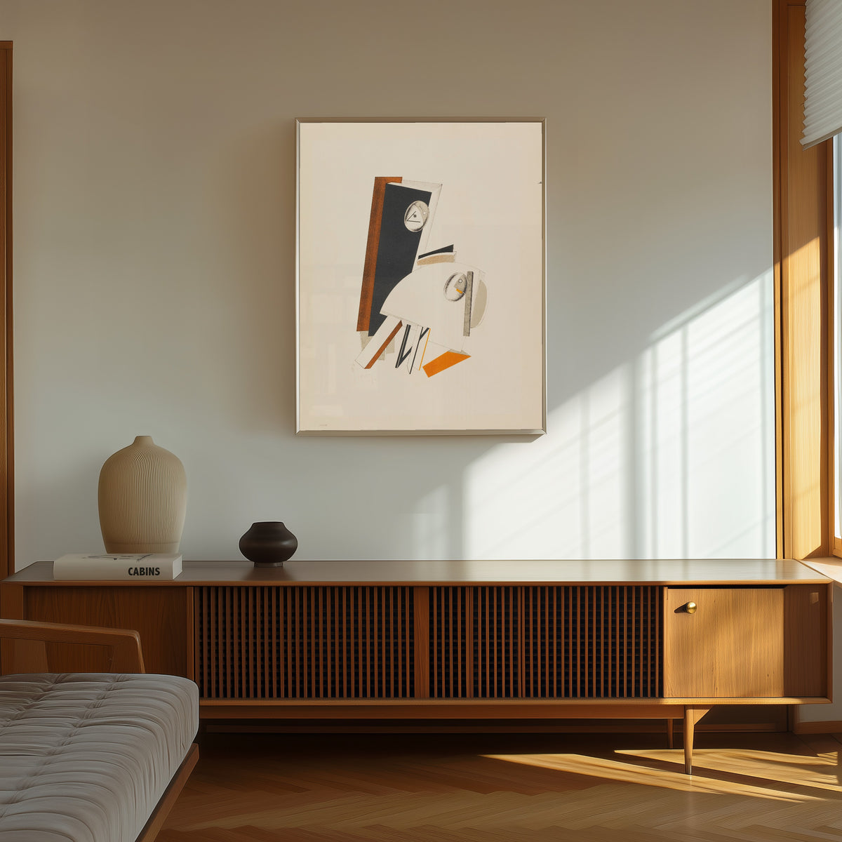 Framed art print of Figurines: The Anxious One (Ängstliche) by El Lissitzky, in a thin light frame on a sunlit wall above a wooden sideboard