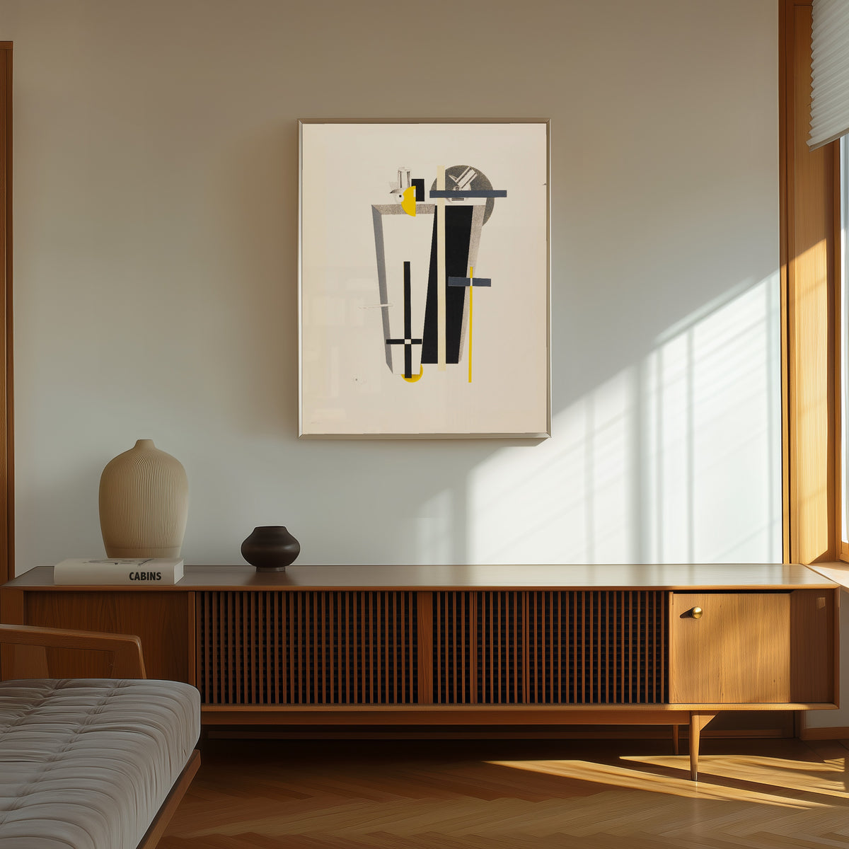 Framed art print of Figurines: The Gravediggers (Totengräber) by El Lissitzky, in a thin light frame on a sunlit wall above a wooden sideboard