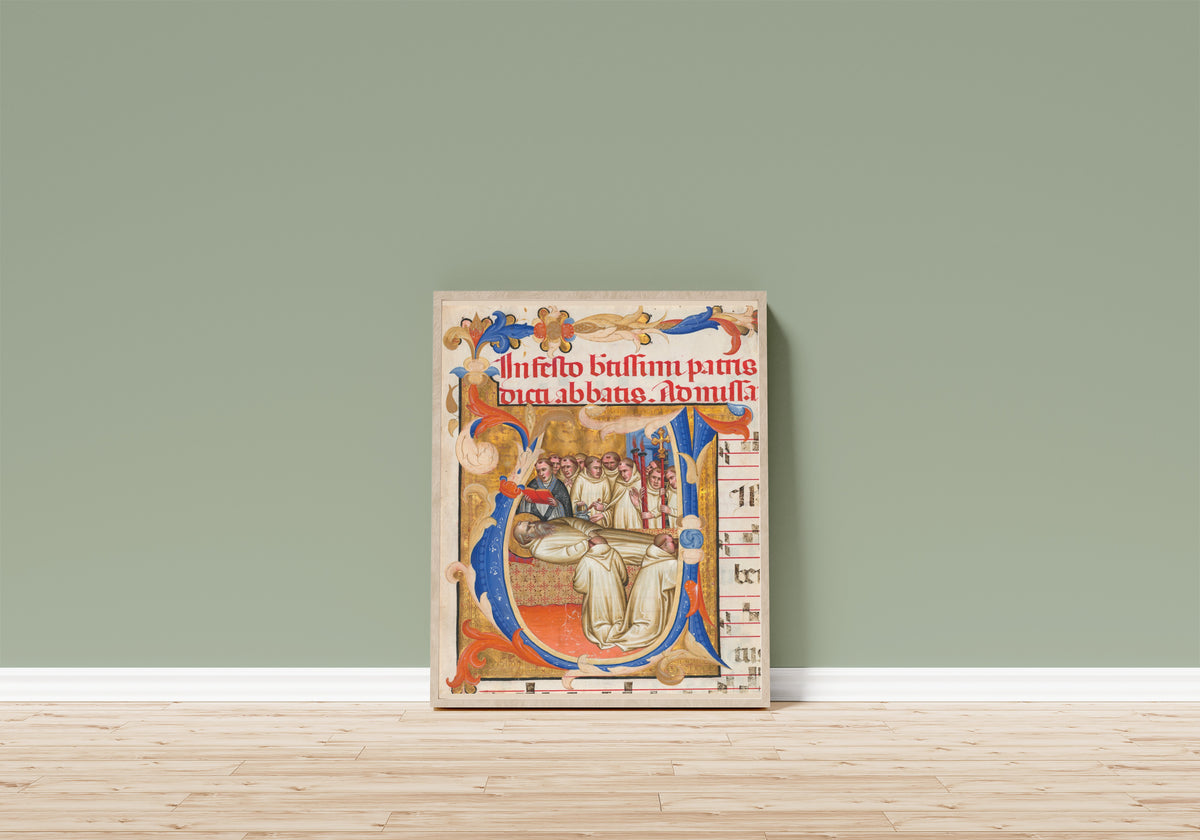 Framed art print of Death of Saint Benedict by Fra Gregorio Mutii da Montalcino, in a light wood frame leaning on a sage green wall above a wooden floor