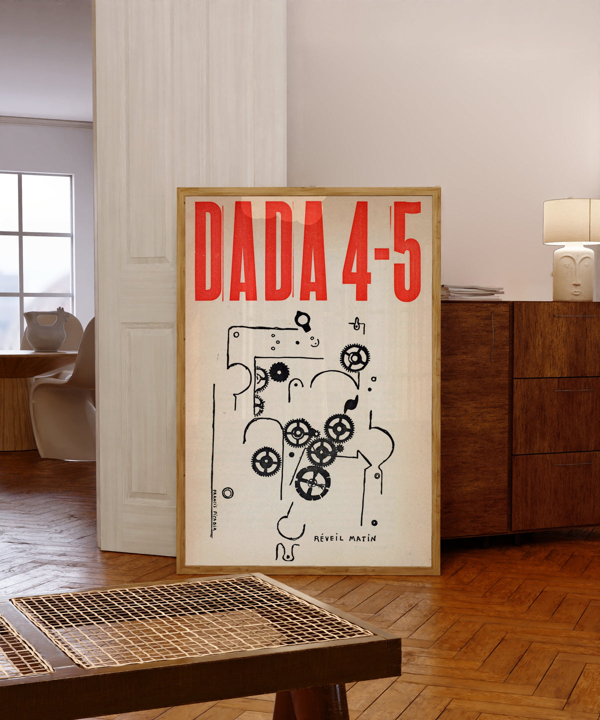 Framed art print of Da-da 4-5 by Francis Picabia, in a light wood frame leaning in a warm room with a parquet floor