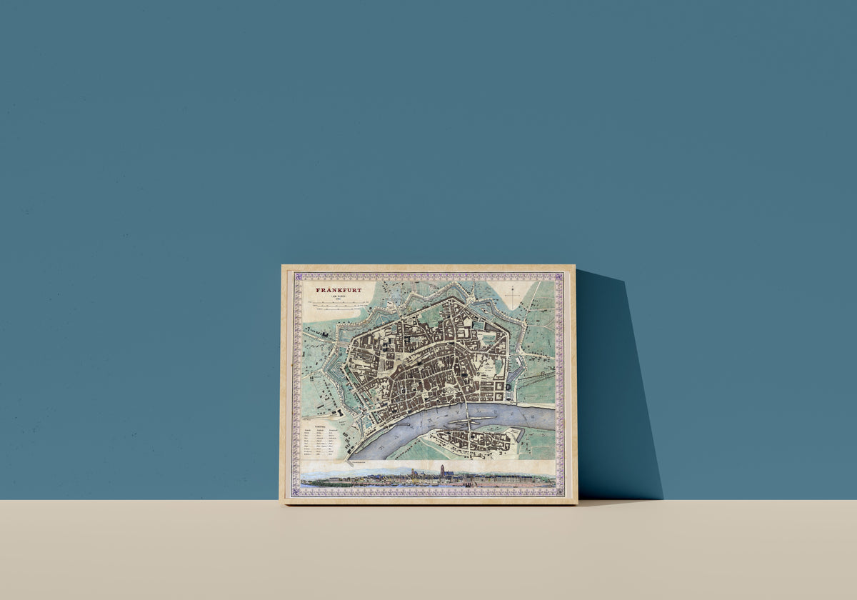 Framed art print of Frankfurt am Main, in a light wood frame leaning on a blue wall