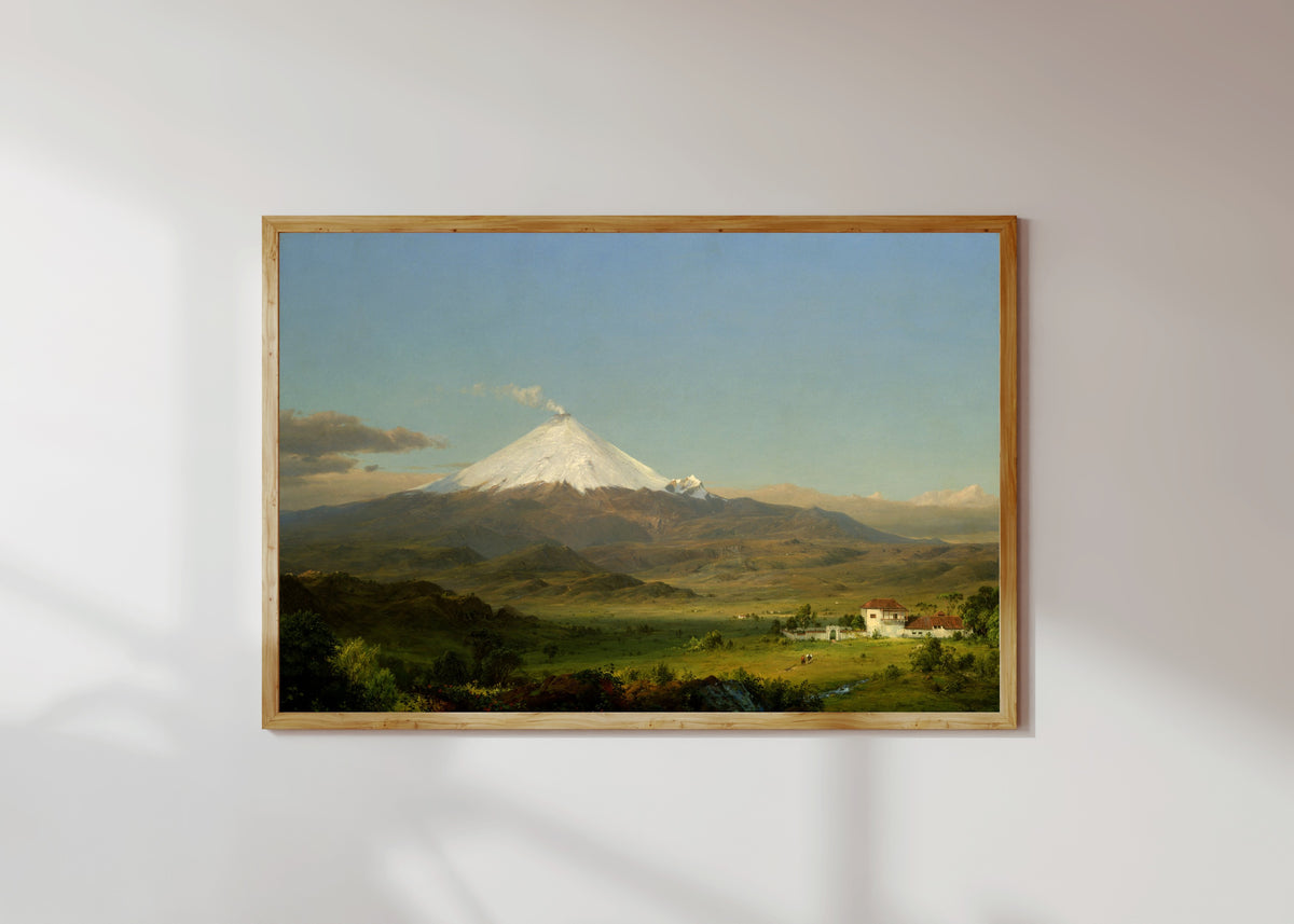 Framed art print of Cotopaxi by Frederic Edwin Church, in a light wood frame on a sunlit white wall