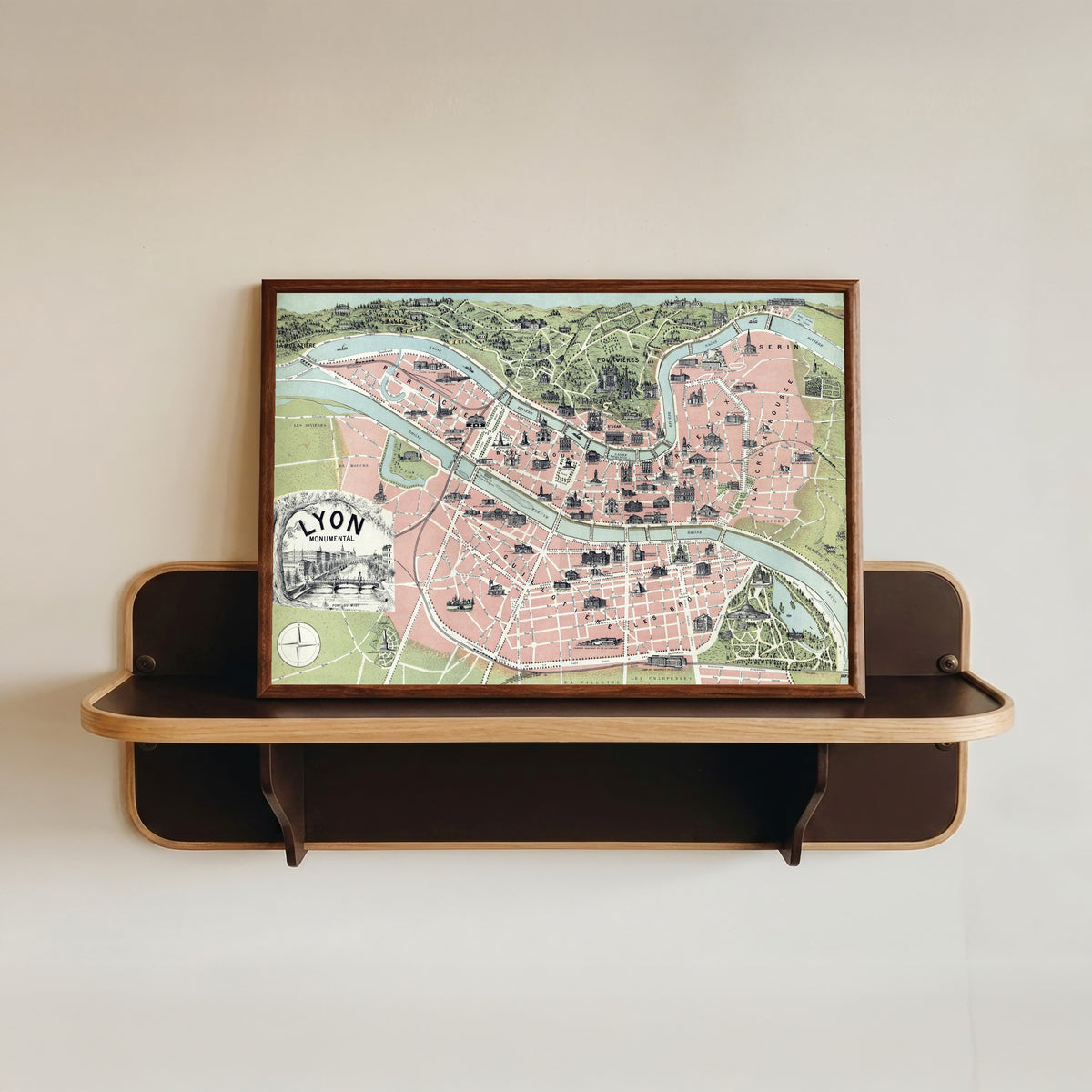Framed art print of Lyon Monumental by Garnier Frères, in a dark wood frame resting on a wall shelf