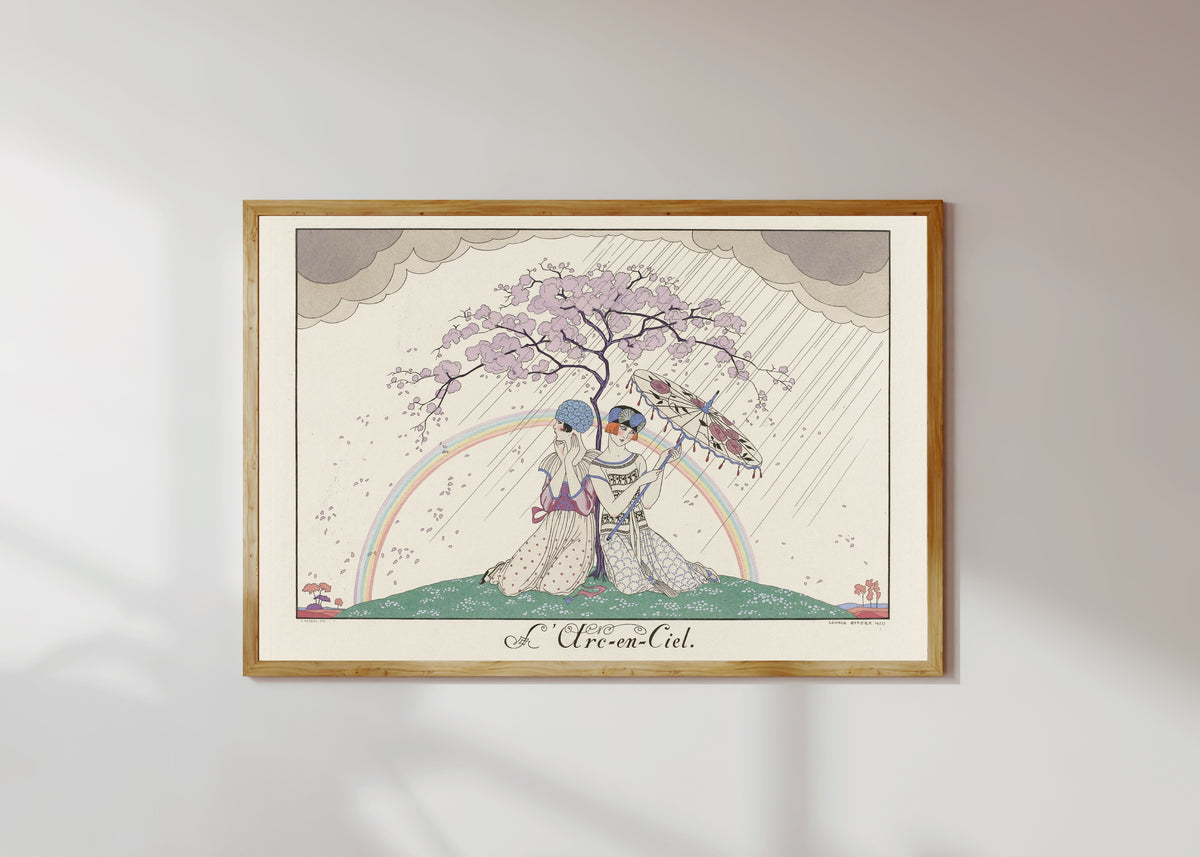 Framed art print of L'Arc-en-ciel [The Rainbow] by George Barbier, in a light wood frame on a sunlit white wall