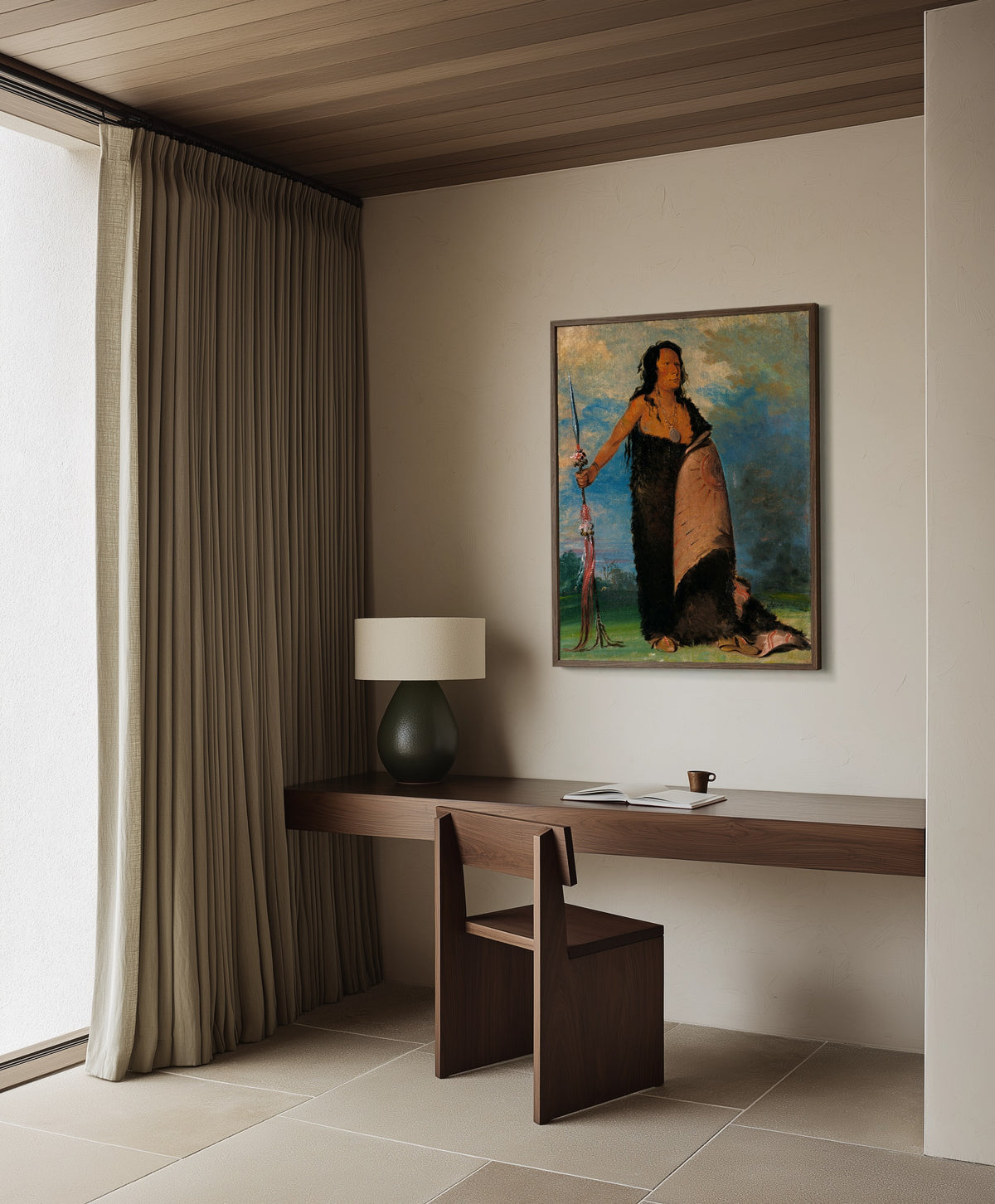 Framed art print of Shoo-de-gá-cha, The Smoke, Chief of the Tribe by George Catlin, in a dark wood frame on a plaster wall above a walnut desk