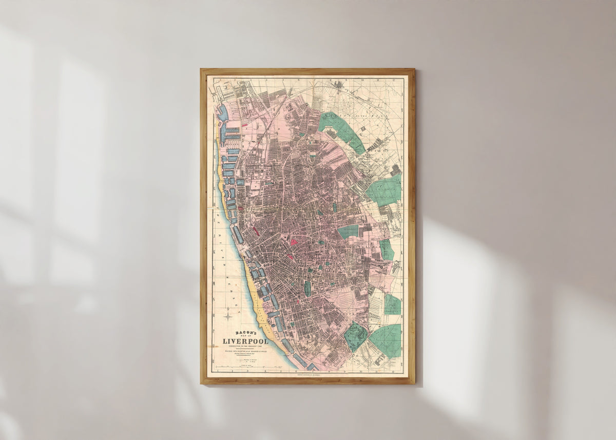Framed art print of Bacon's Map of Liverpool by George Washington Bacon, in a light wood frame on a sunlit white wall