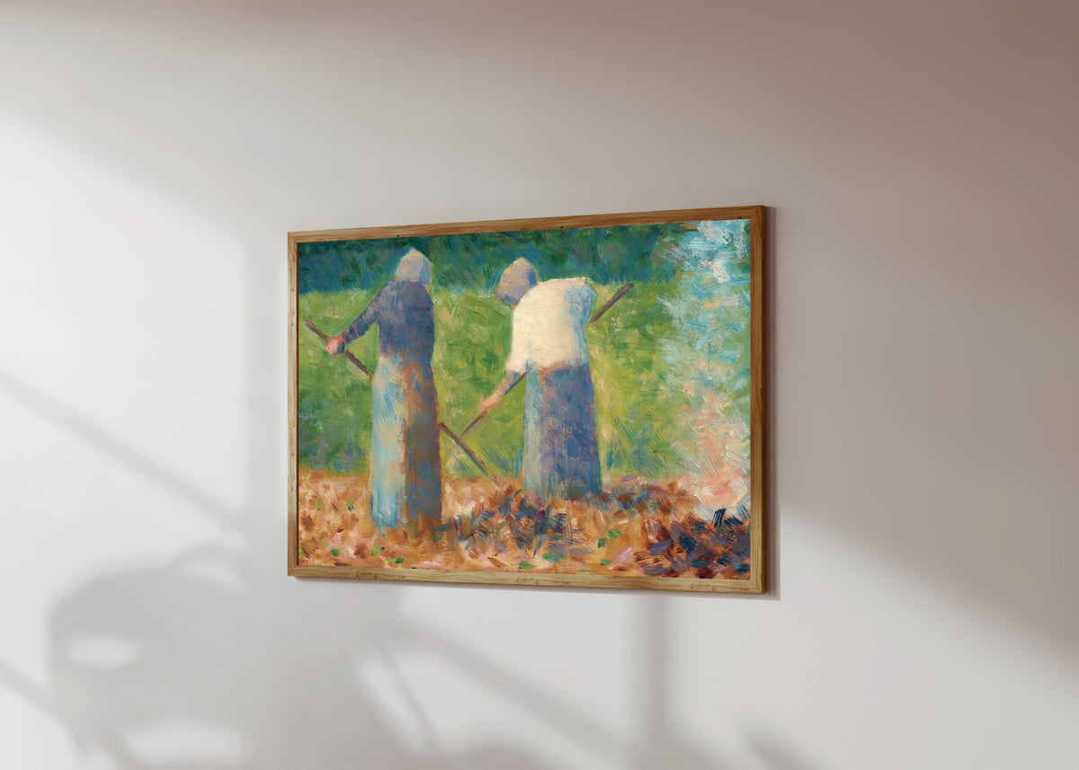 Framed art print of Haymakers at Montfermeil by Georges Seurat, in a light wood frame on a sunlit white wall, seen at a slight angle