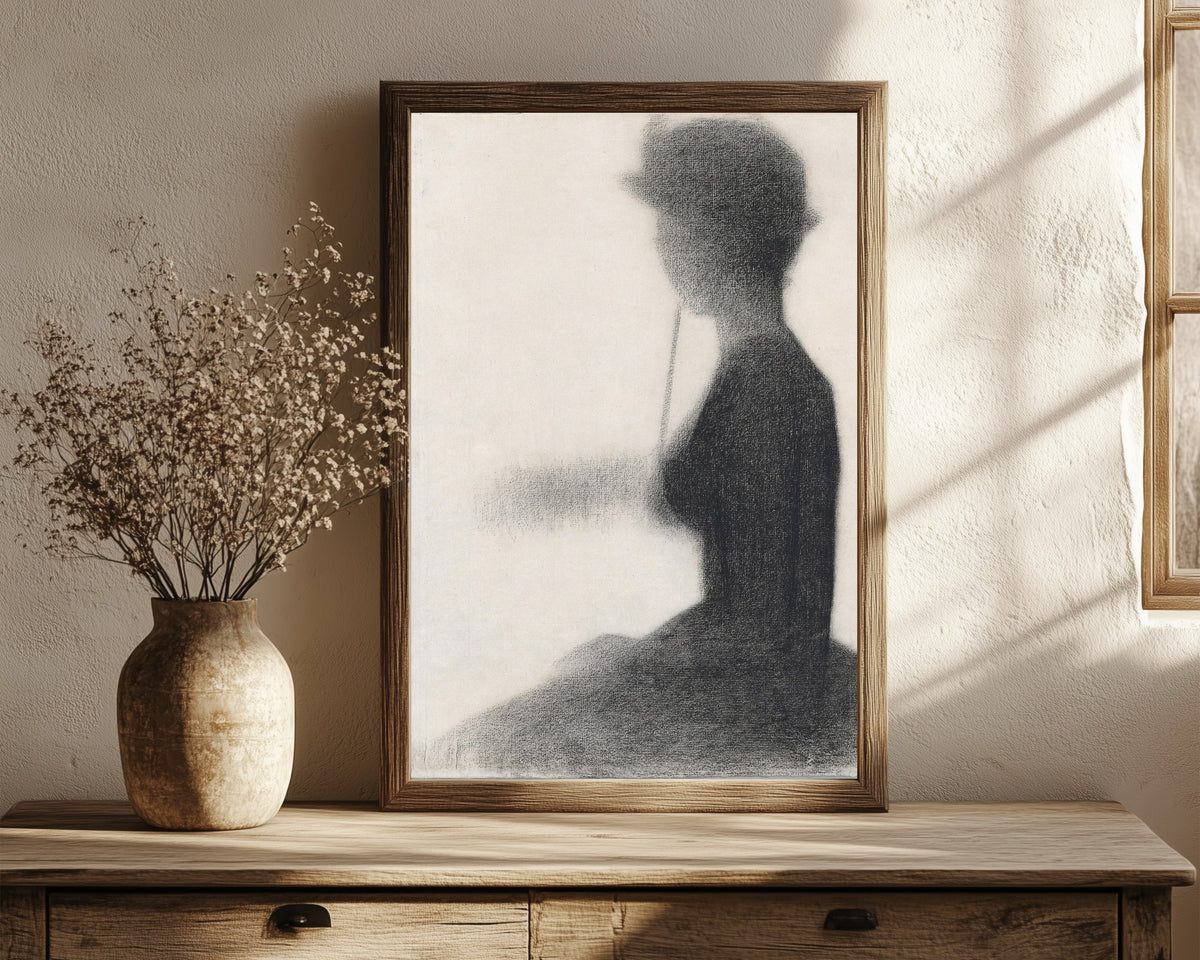 Framed art print of Seated Woman with a Parasol (study for La Grande… by Georges Seurat, in a dark wood frame leaning on a rustic console beside dried flowers