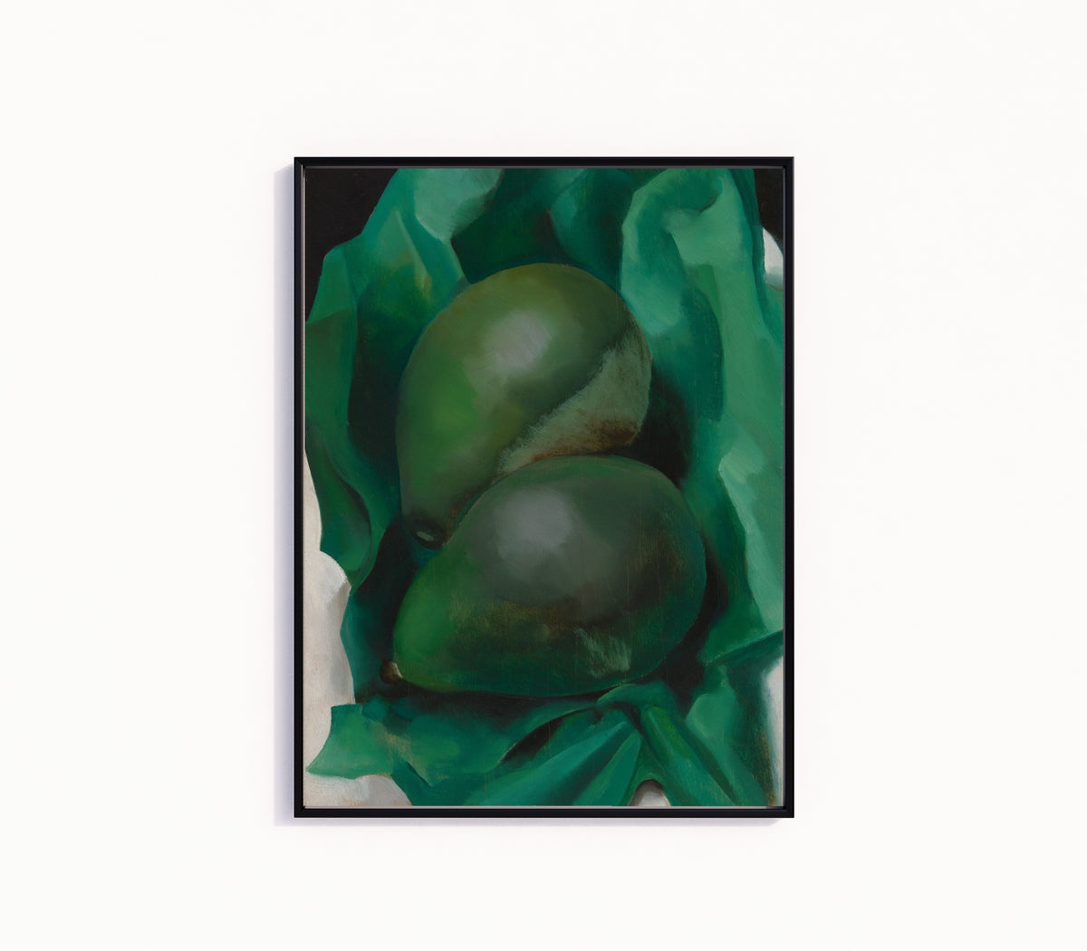 Framed art print of Alligator Pears by Georgia O'Keeffe, in a slim black frame on a plain white wall