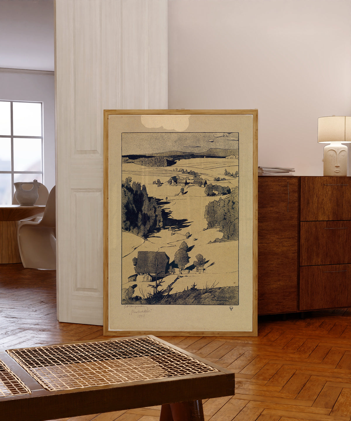 Framed art print of Glasbachthal by Gustav Kampmann, in a light wood frame leaning in a warm room with a parquet floor