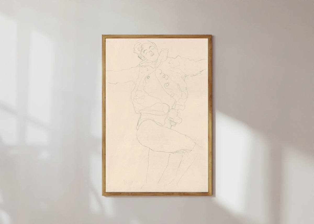 Framed art print of Dancing Woman with Cape by Gustav Klimt, in a light wood frame on a sunlit white wall