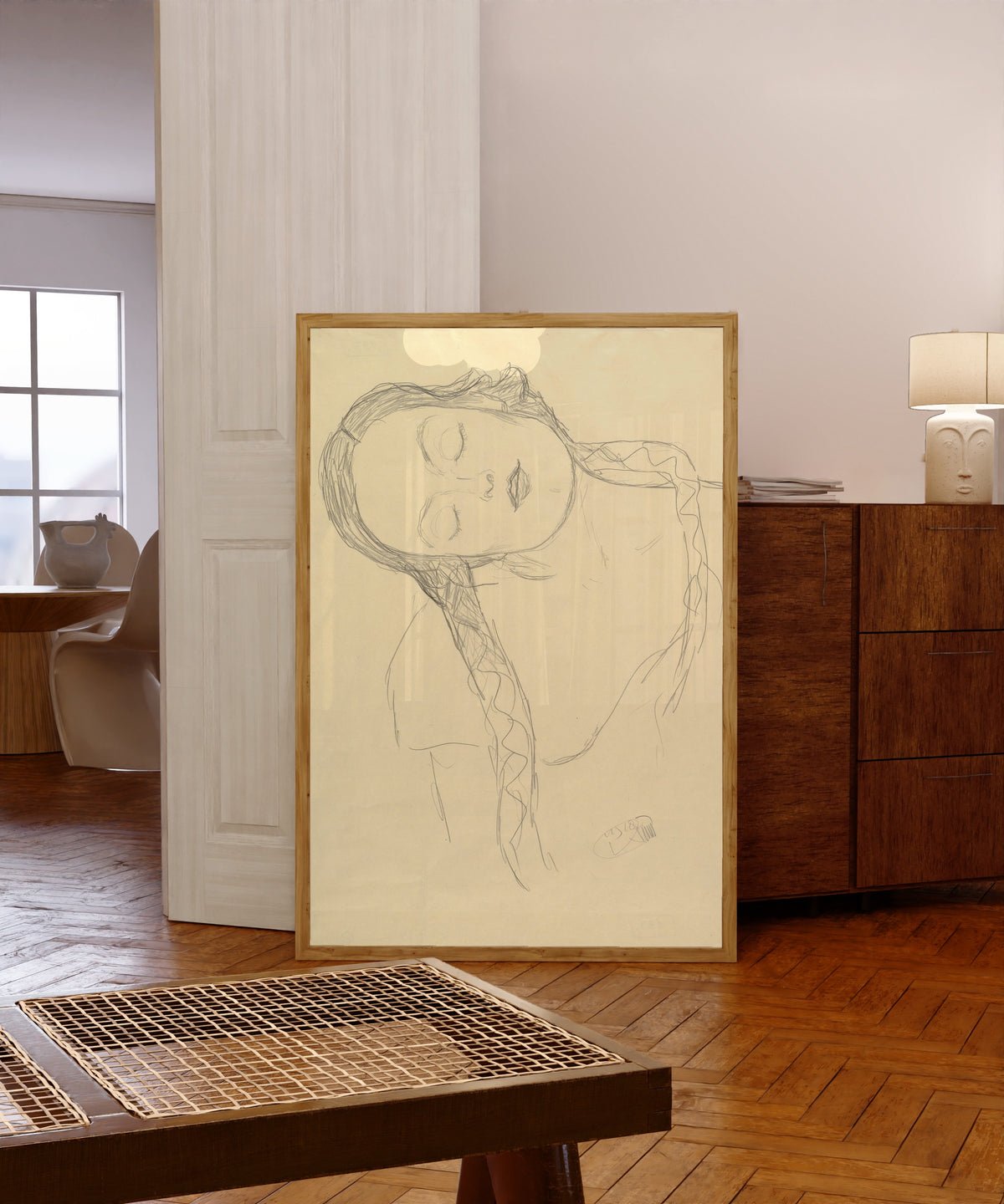 Framed art print of Half-figure of a Young Woman by Gustav Klimt, in a light wood frame leaning in a warm room with a parquet floor