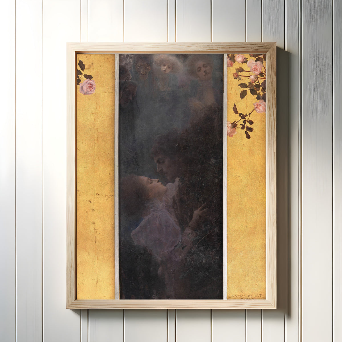 Framed art print of Love (Liebe) by Gustav Klimt, in a light wood frame on a white panelled wall