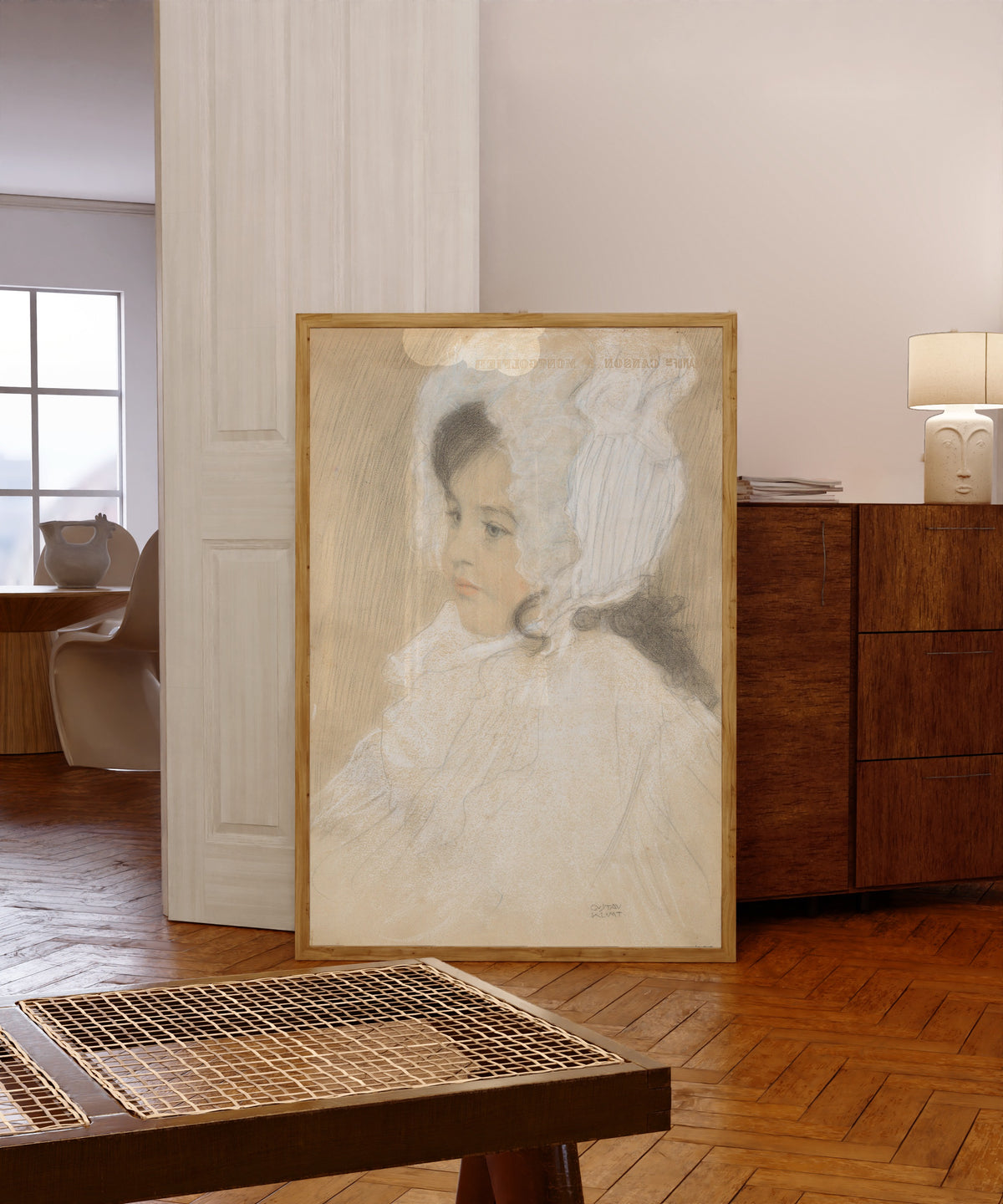 Framed art print of Portrait of a Child (Marie Moll) by Gustav Klimt, in a light wood frame leaning in a warm room with a parquet floor
