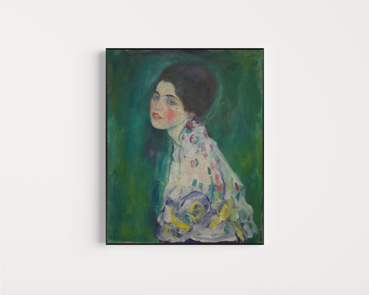 Framed art print of Portrait of a Lady by Gustav Klimt, in a slim black frame on a plain white wall