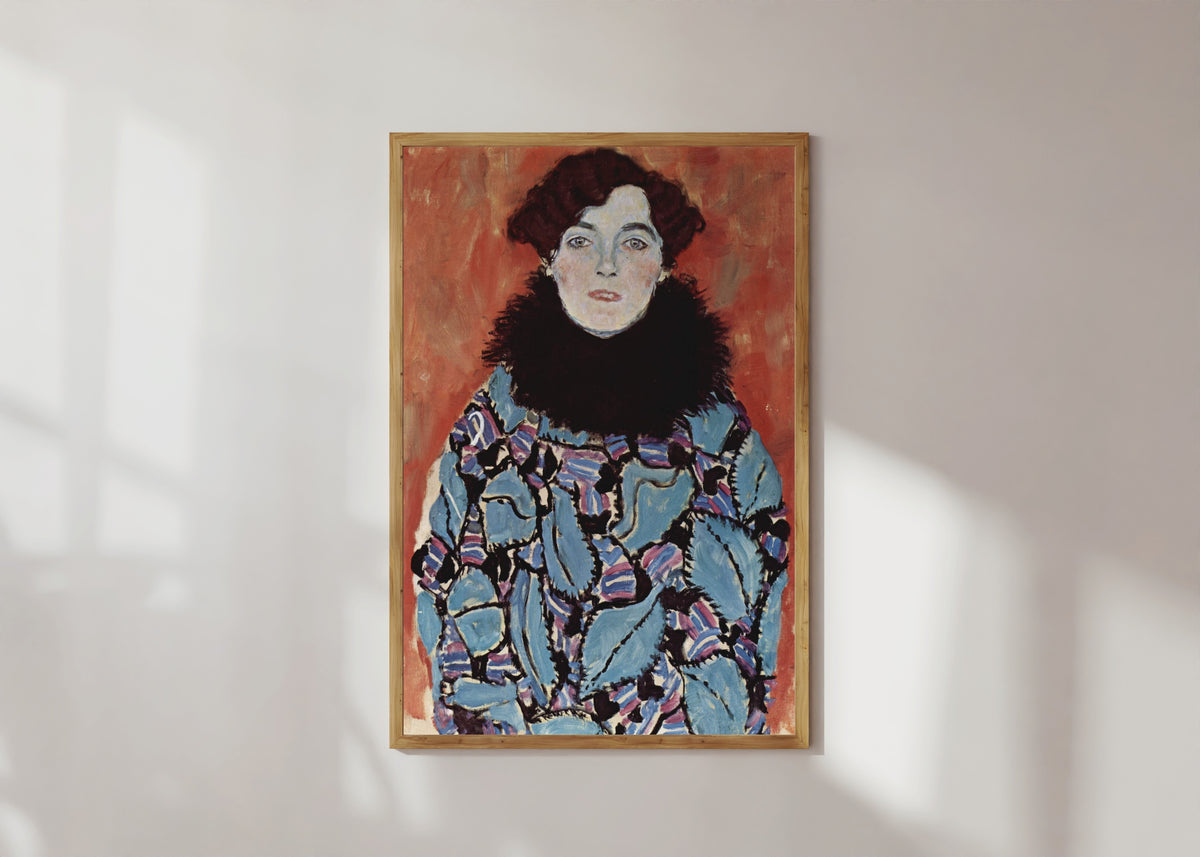 Framed art print of Portrait of Johanna Staude by Gustav Klimt, in a light wood frame on a sunlit white wall