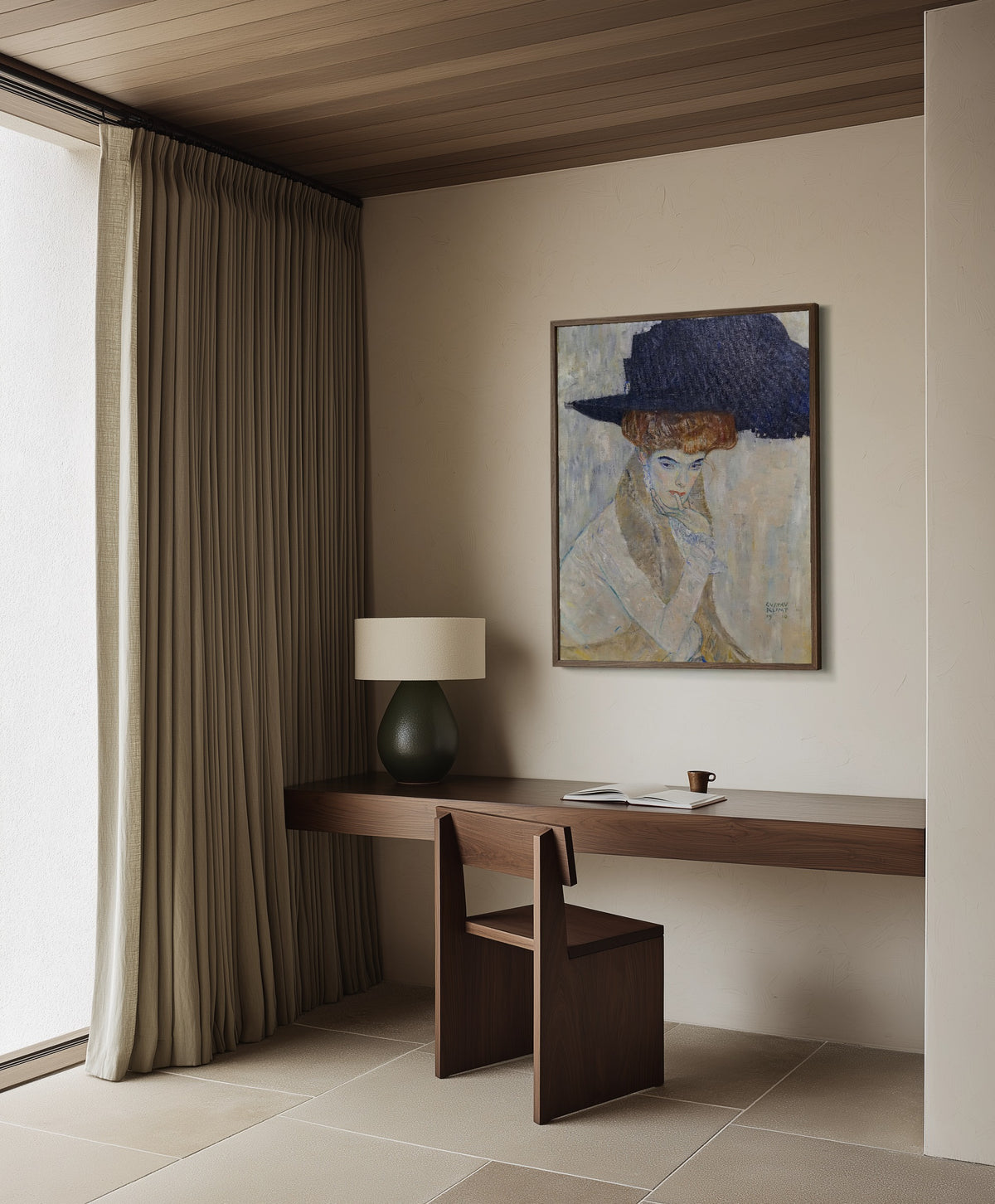 Framed art print of The Black Feathered Hat by Gustav Klimt, in a dark wood frame on a plaster wall above a walnut desk