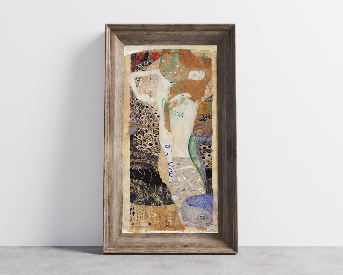 Framed art print of Water Serpents I (Friends) by Gustav Klimt, in a wide wooden frame leaning against a concrete wall