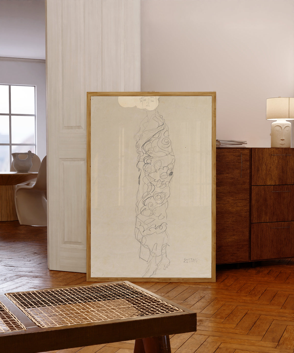 Framed art print of Woman in Kimono by Gustav Klimt, in a light wood frame leaning in a warm room with a parquet floor