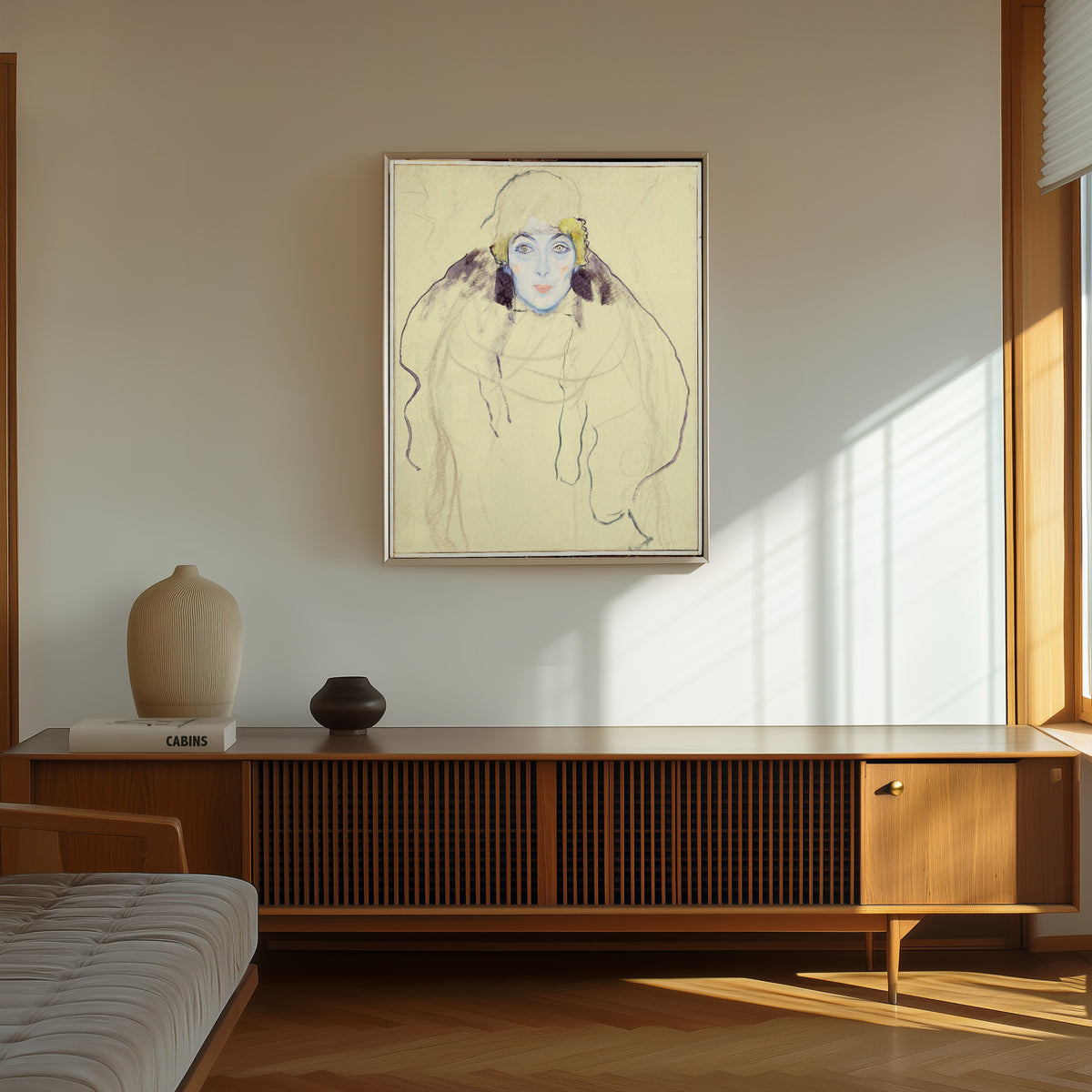 Framed art print of Woman's Head by Gustav Klimt, in a thin light frame on a sunlit wall above a wooden sideboard