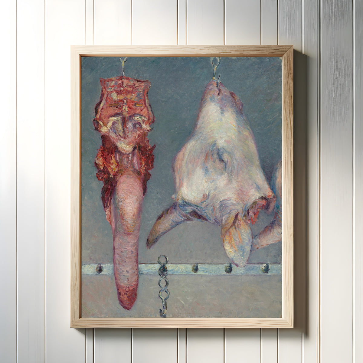 Framed art print of Calf's Head and Ox Tongue by Gustave Caillebotte, in a light wood frame on a white panelled wall