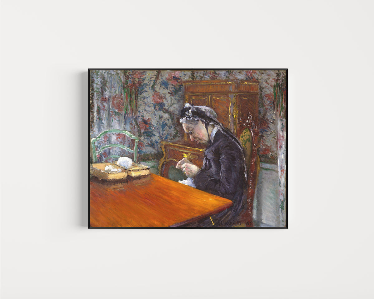 Framed art print of Mademoiselle Boissière Knitting by Gustave Caillebotte, in a slim black frame on a plain white wall