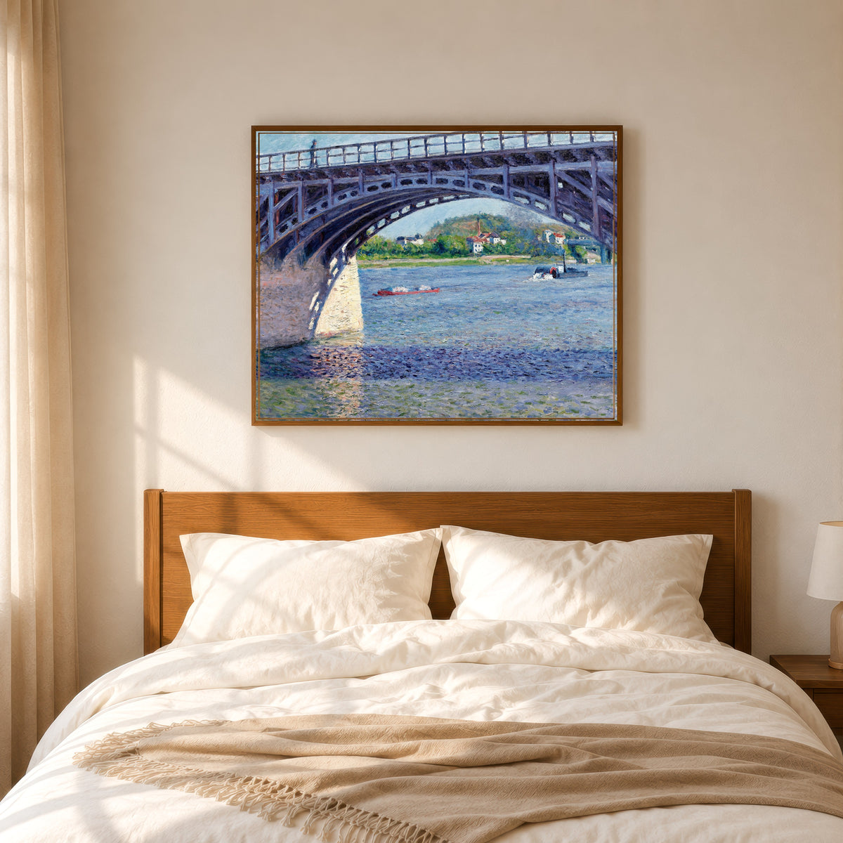 Framed art print of The Argenteuil Bridge and the Seine by Gustave Caillebotte, in a slim wood frame above a bed in a sunlit bedroom