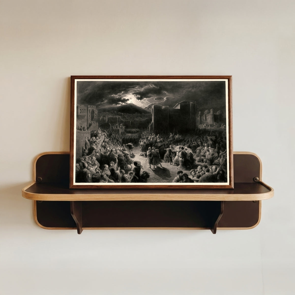 Framed art print of Crucifixion Scene in a Storm-lit Town by Gustave Doré, in a dark wood frame resting on a wall shelf