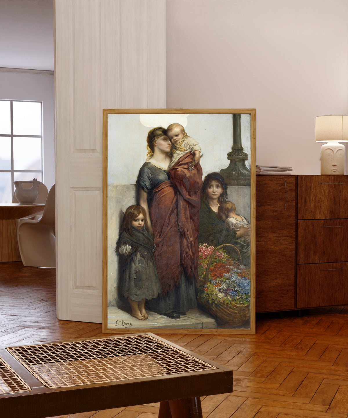 Framed art print of Flower Sellers of London by Gustave Doré, in a light wood frame leaning in a warm room with a parquet floor