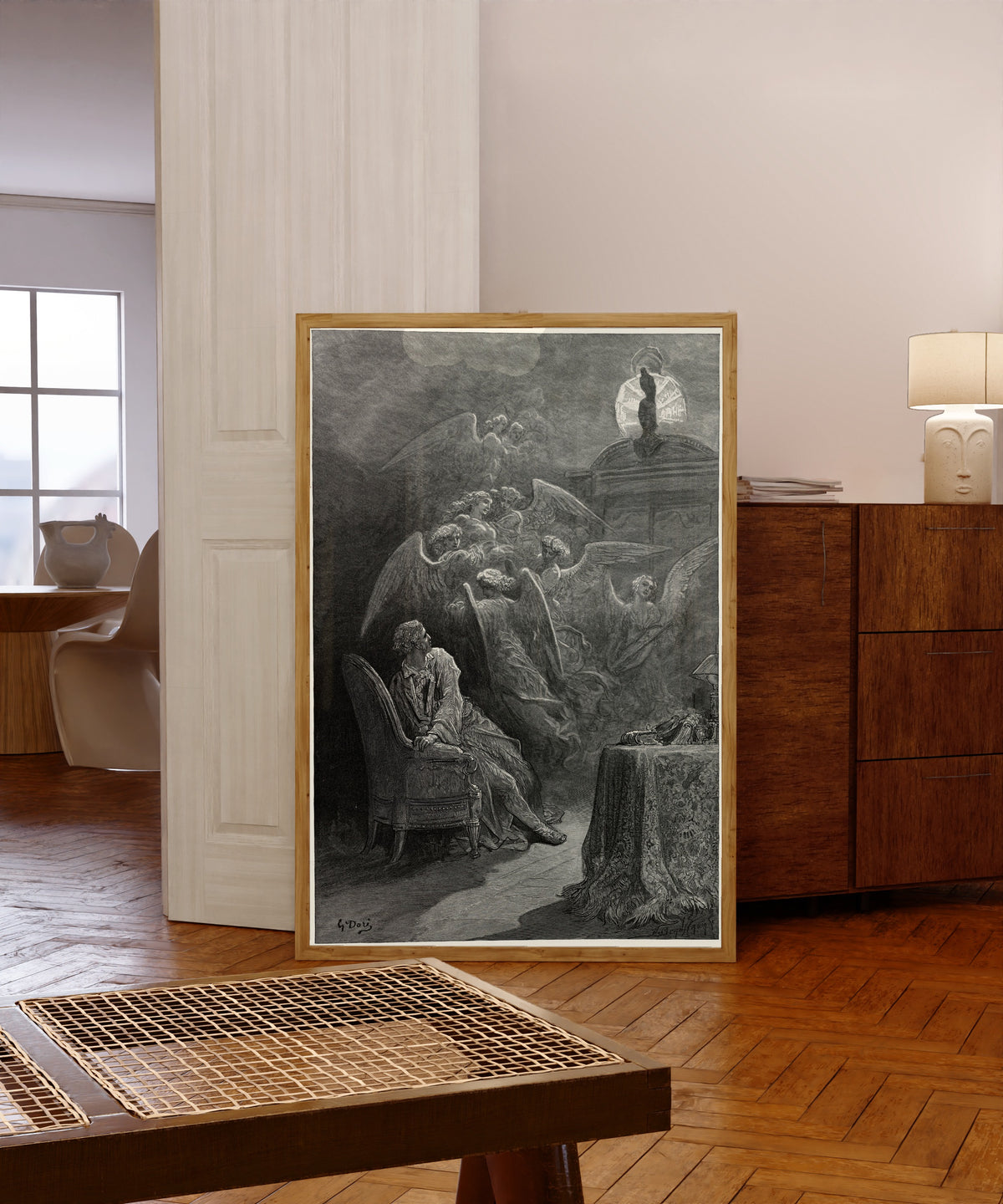 Framed art print of Respite and nepenthe from thy memories of Lenore by Gustave Doré, in a light wood frame leaning in a warm room with a parquet floor