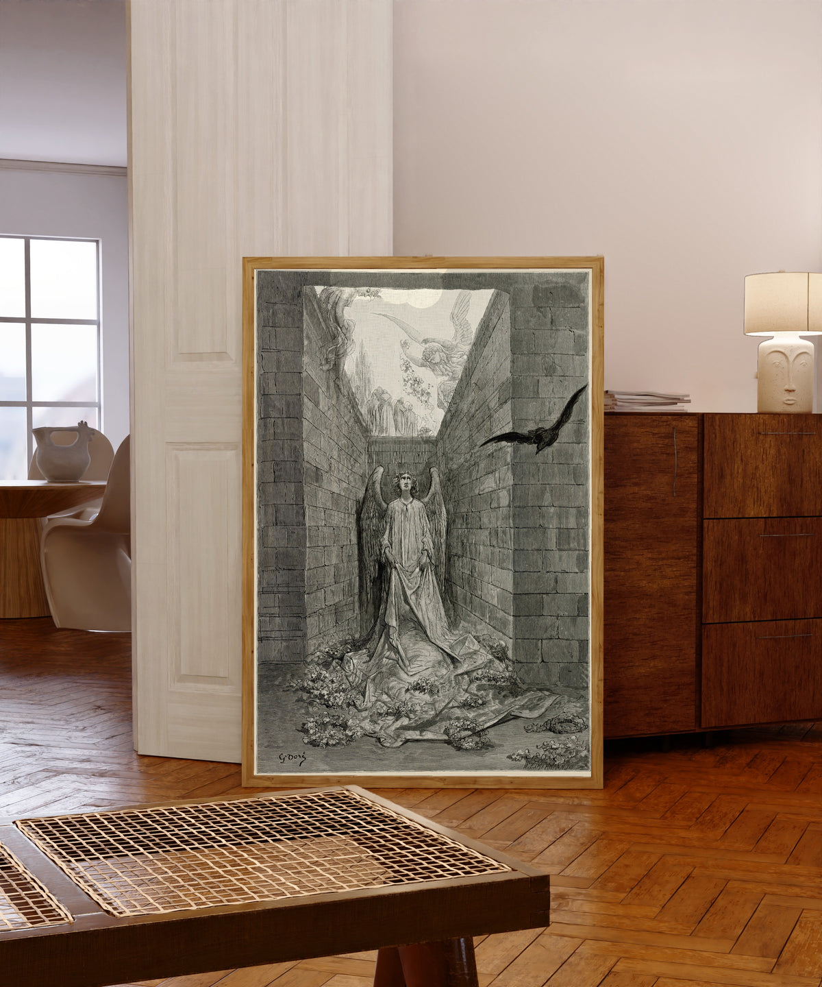 Framed art print of Sorrow for the lost Lenore by Gustave Doré, in a light wood frame leaning in a warm room with a parquet floor
