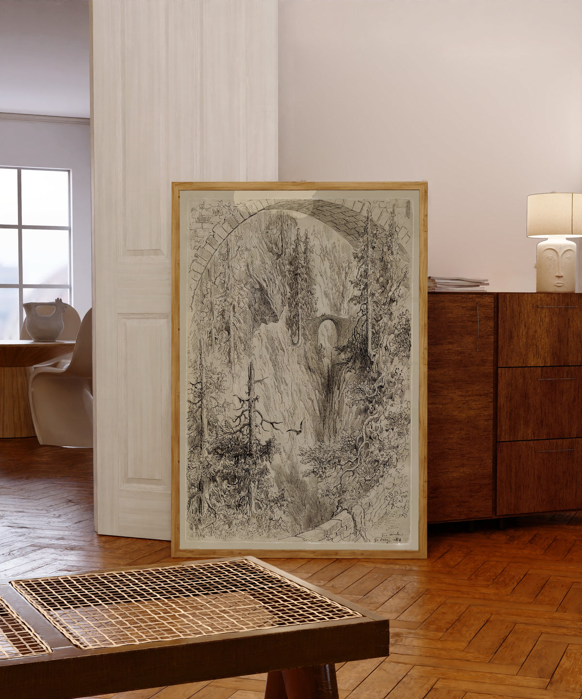 Framed art print of Via Mala by Gustave Doré, in a light wood frame leaning in a warm room with a parquet floor