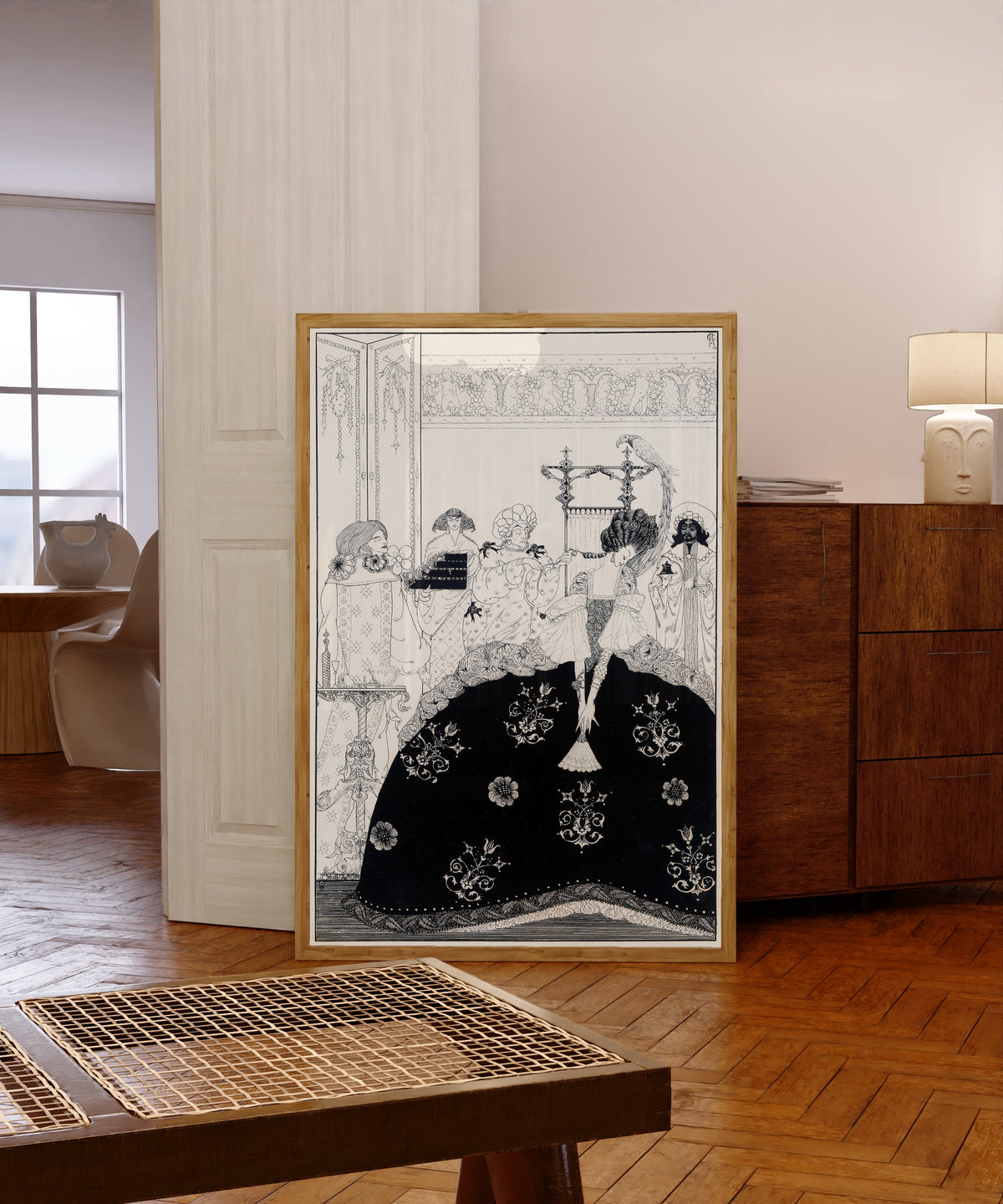 Framed art print of Now Awful Beauty Puts on All Its Arms by Harry Clarke, in a light wood frame leaning in a warm room with a parquet floor