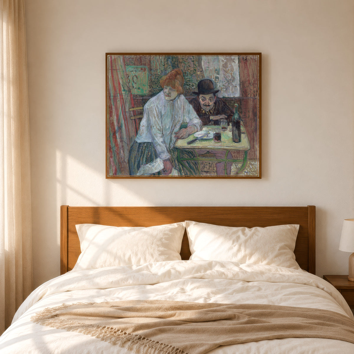 Framed art print of At the Café La Mie by Henri de Toulouse-Lautrec, in a slim wood frame above a bed in a sunlit bedroom