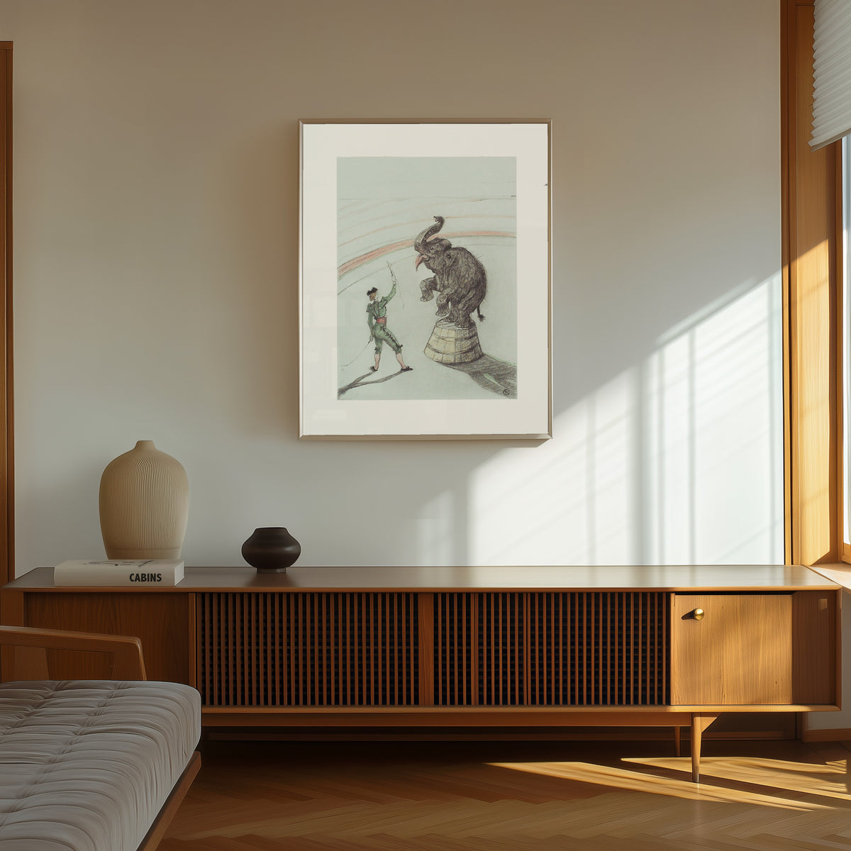 Framed art print of Au Cirque: Éléphant en liberté by Henri de Toulouse-Lautrec, in a thin light frame on a sunlit wall above a wooden sideboard