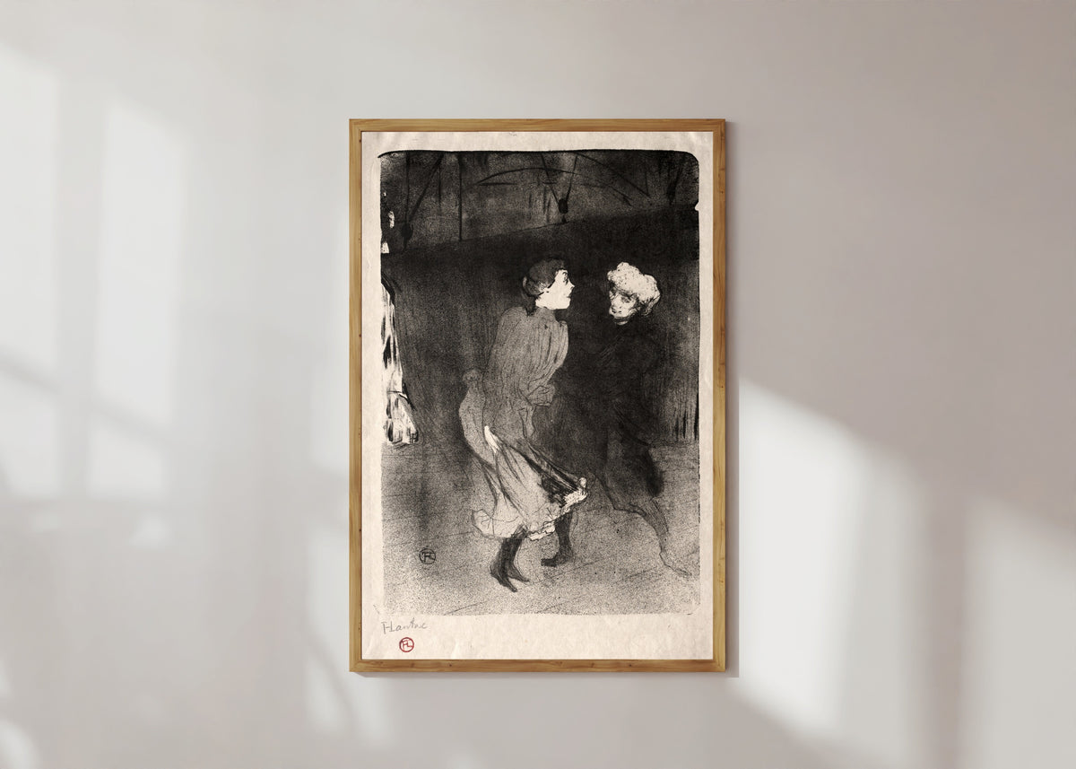 Framed art print of Emilienne d'Alençon and Mariquita of the Folies-Bergère by Henri de Toulouse-Lautrec, in a light wood frame on a sunlit white wall